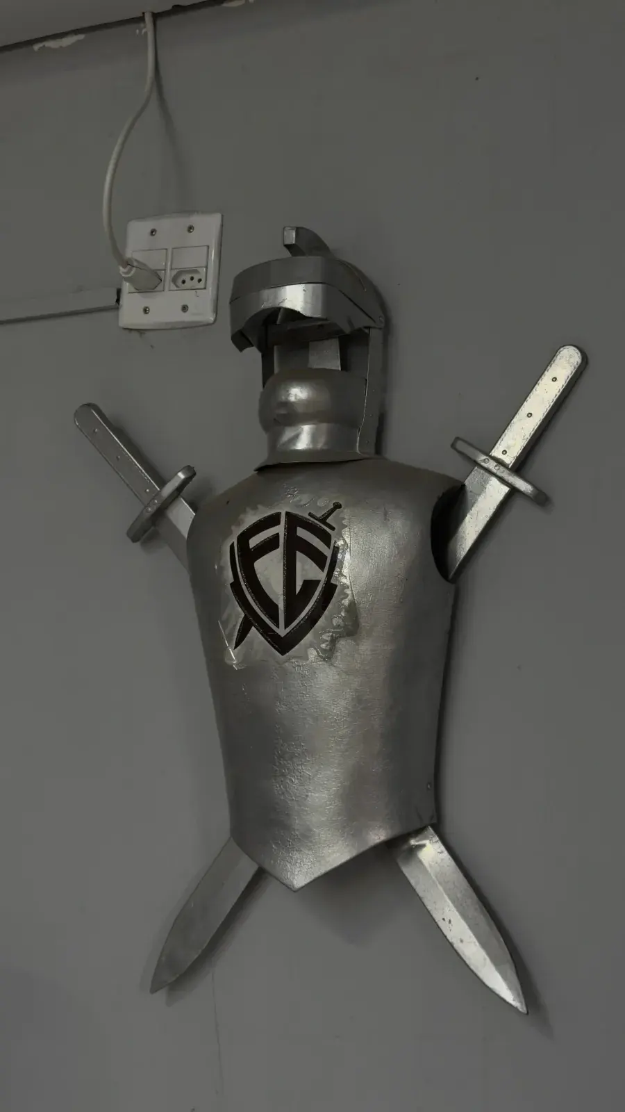 Armadura de metal na parede da Barbearia Quintana